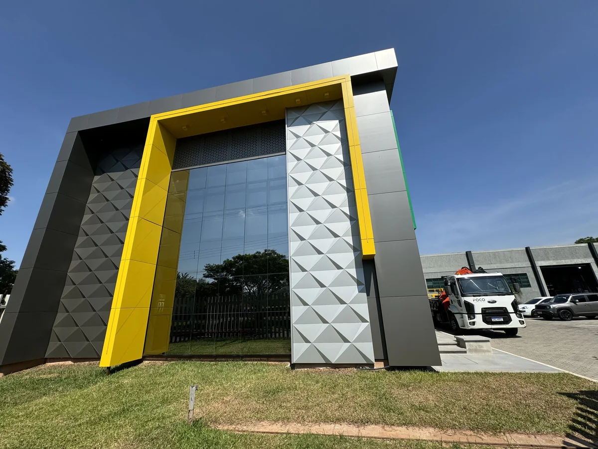Silver faceted 3D ACM panels with yellow ACM framing on a building entrance