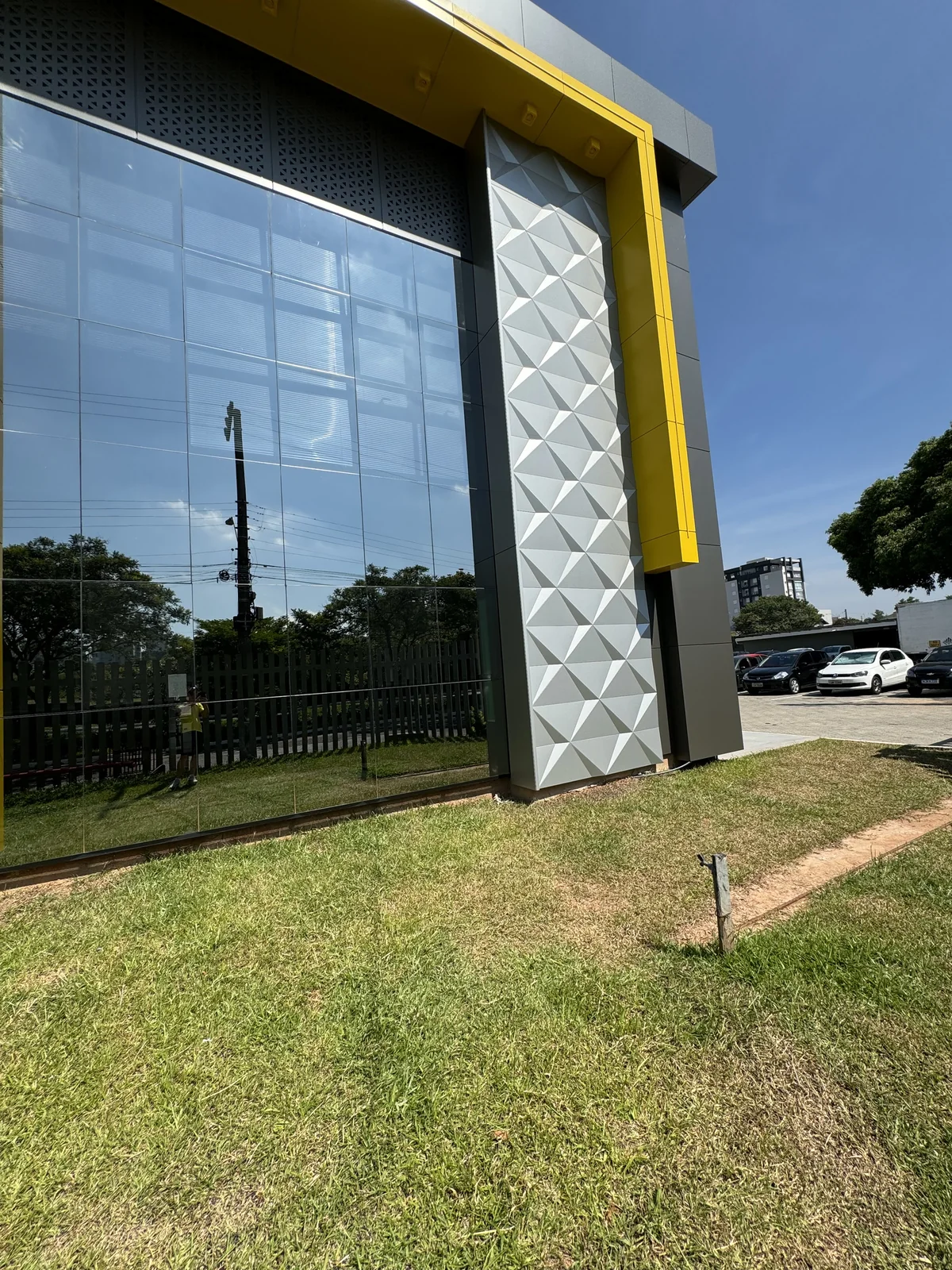 Glazed entrance flanked by a silver 3D ACM panel column and yellow ACM frame