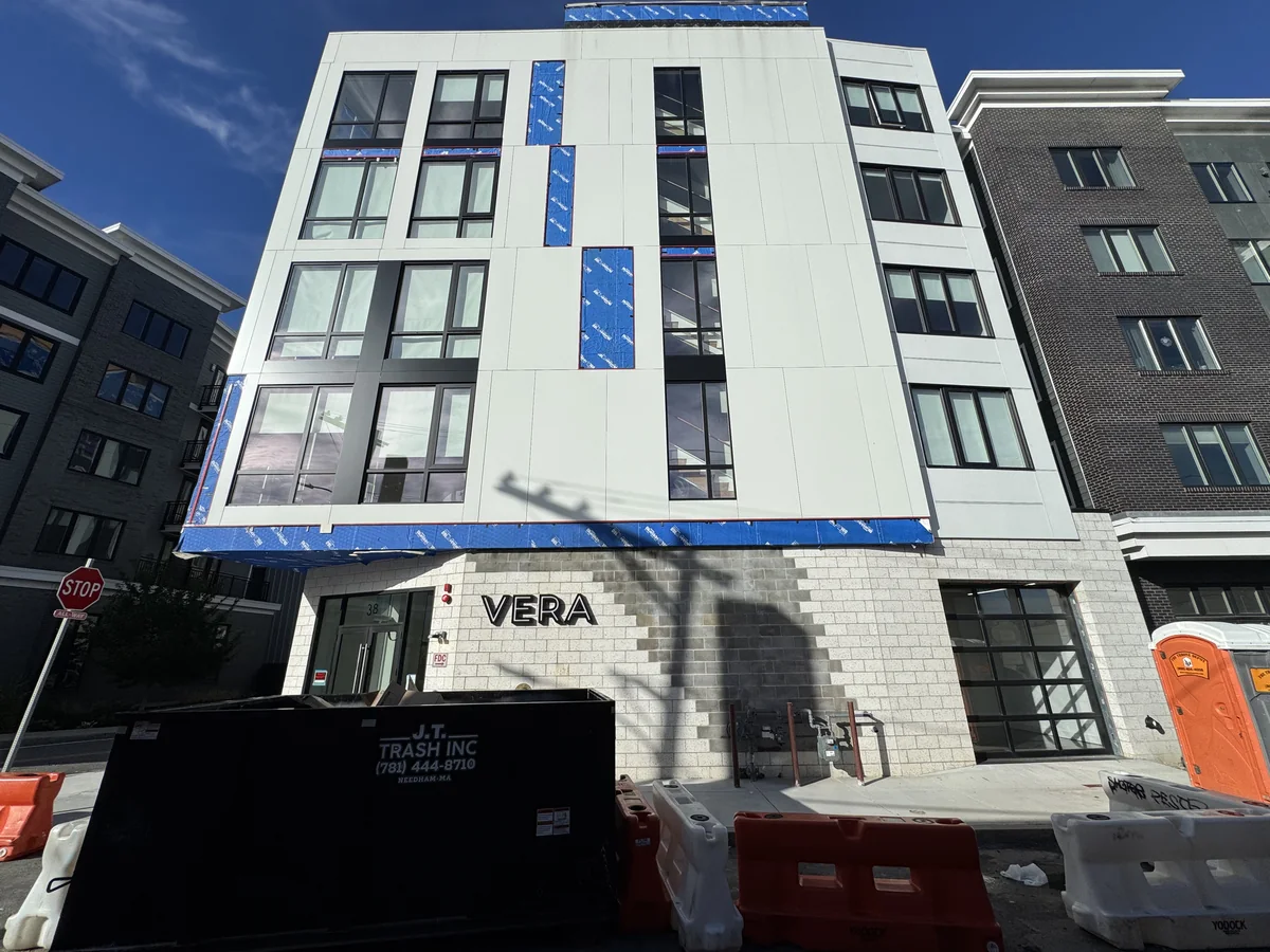 White ACM panels being installed on the VERA building in Boston, with blue weather barrier still visible