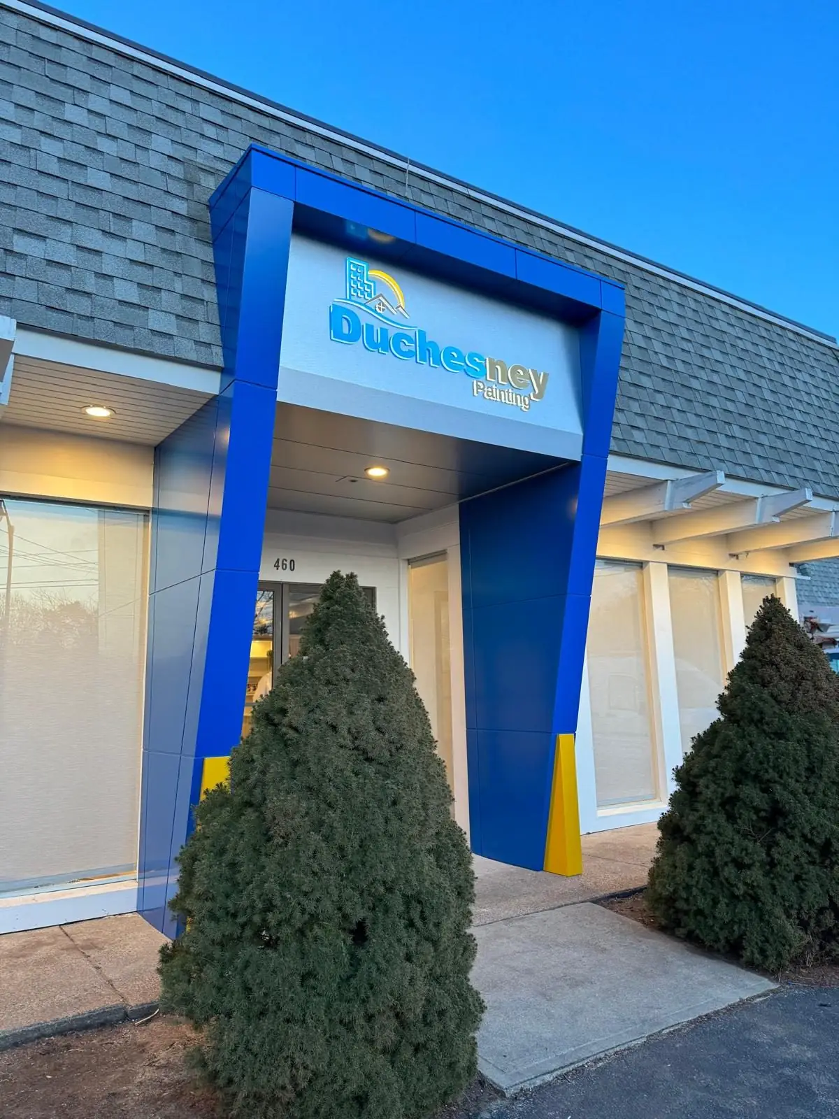 Blue ACM entrance portal with yellow accents at Duchesney Painting, Hyannis