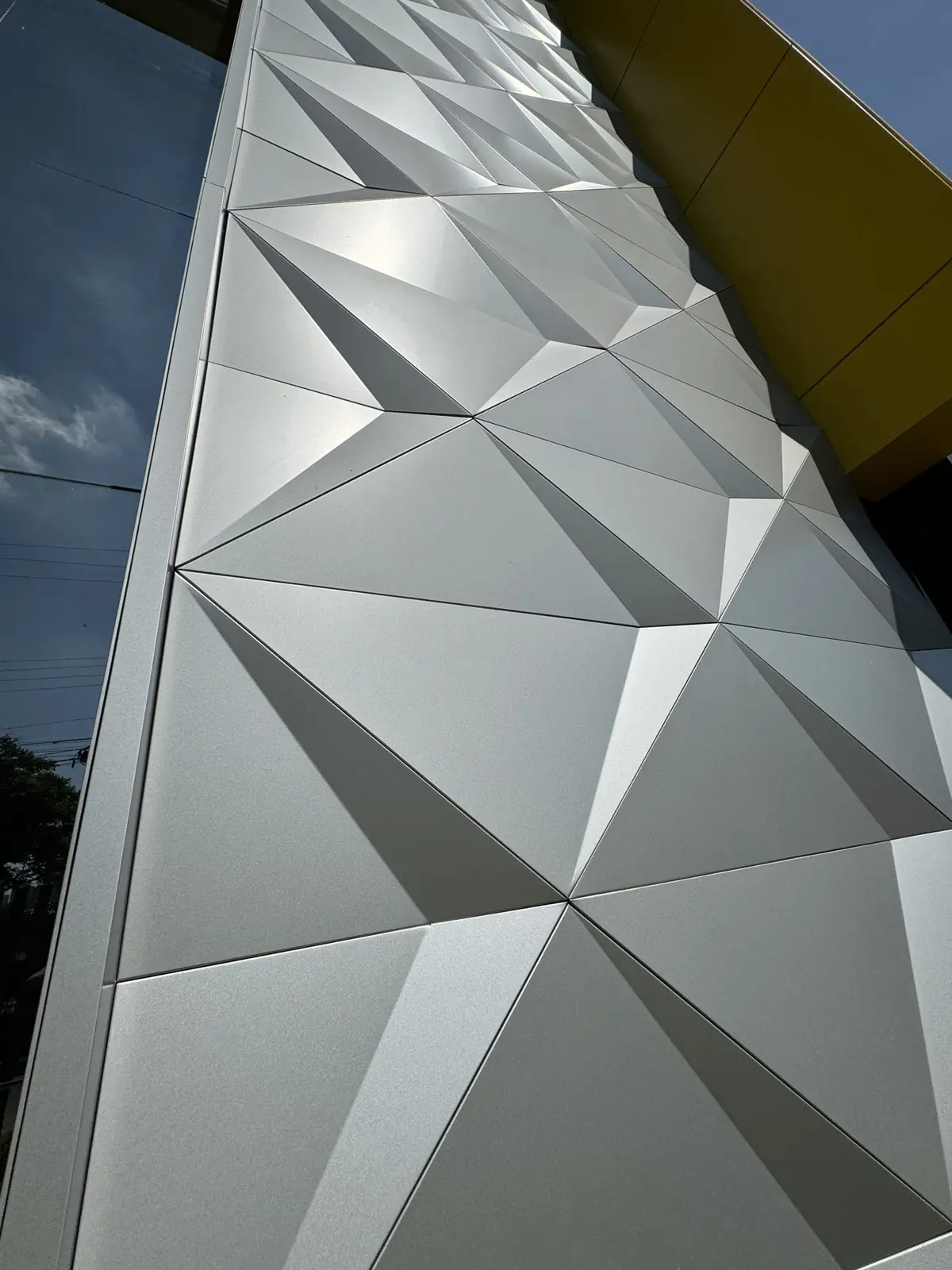 Close detail of folded 3D ACM facets in a brushed silver finish