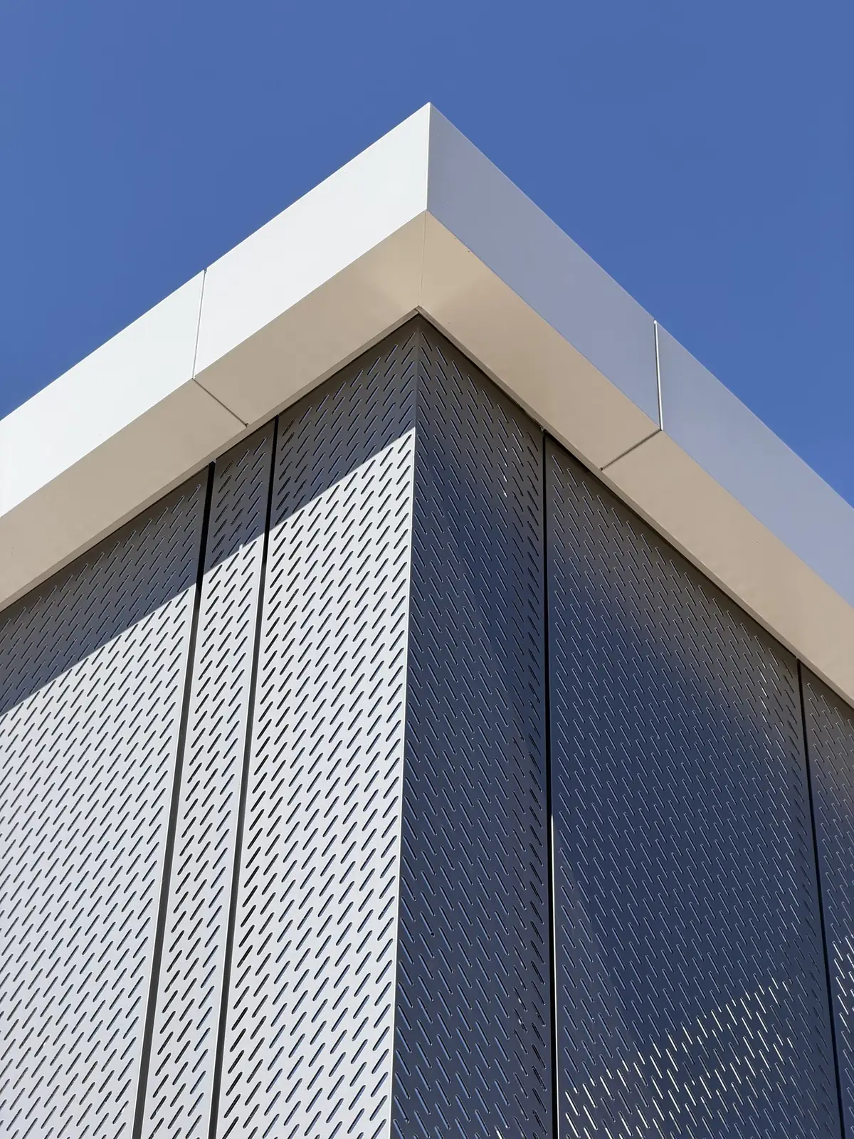Perforated ACM panels meeting at a precise building corner