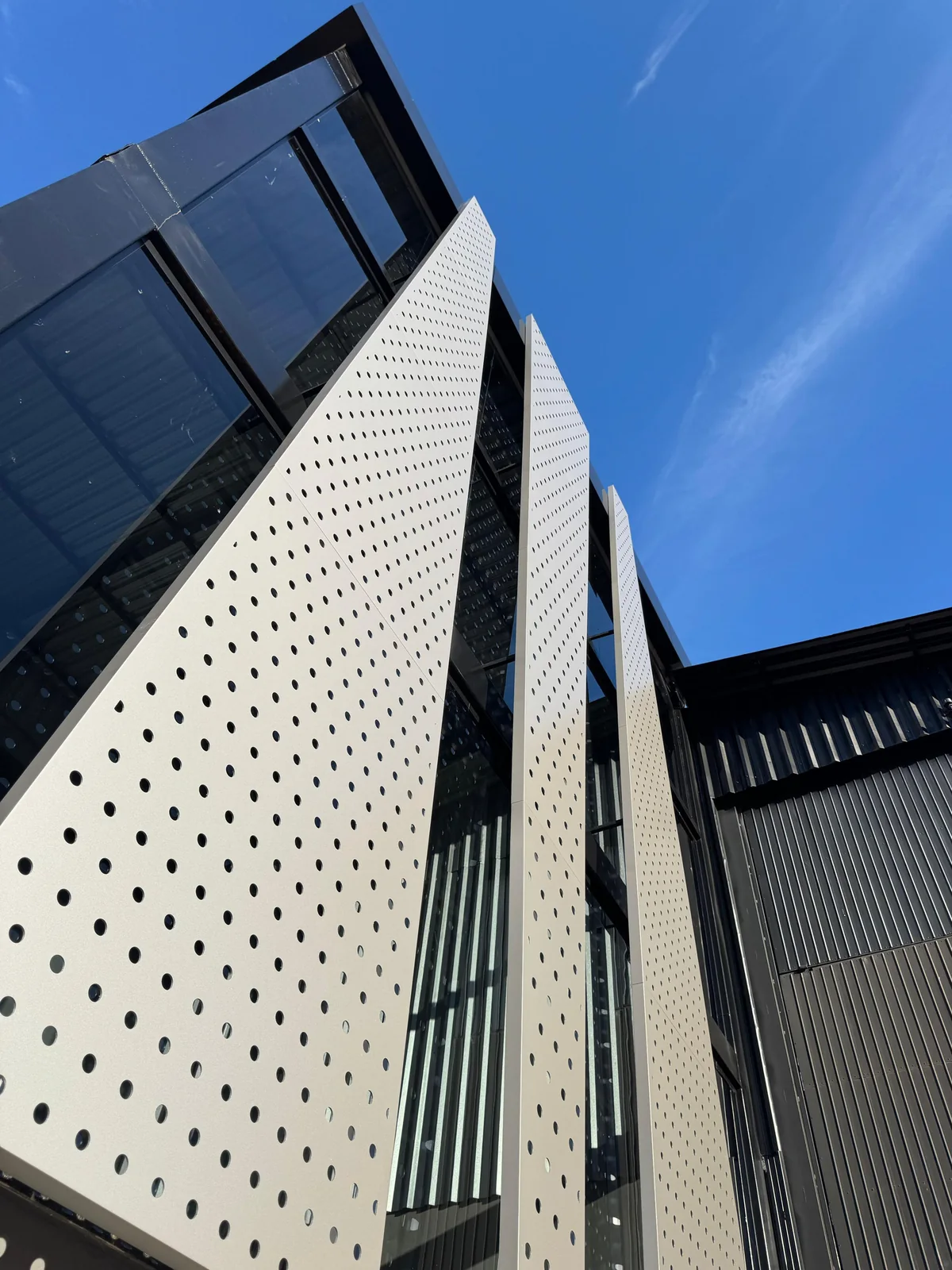 Large angled perforated ACM panel against a blue sky