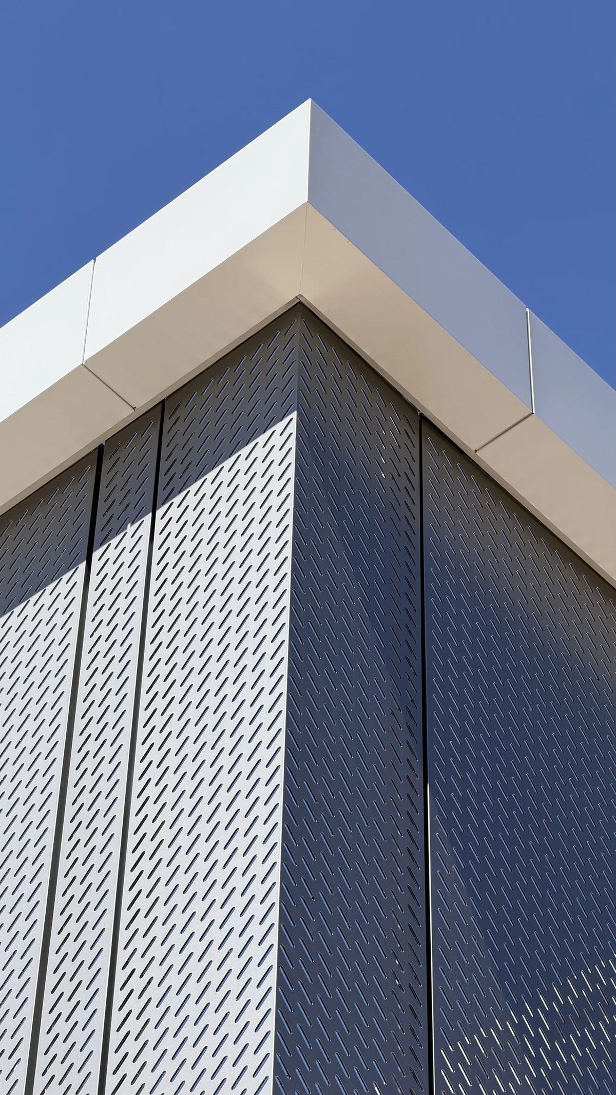 Slotted perforated ACM panels wrapping a building corner
