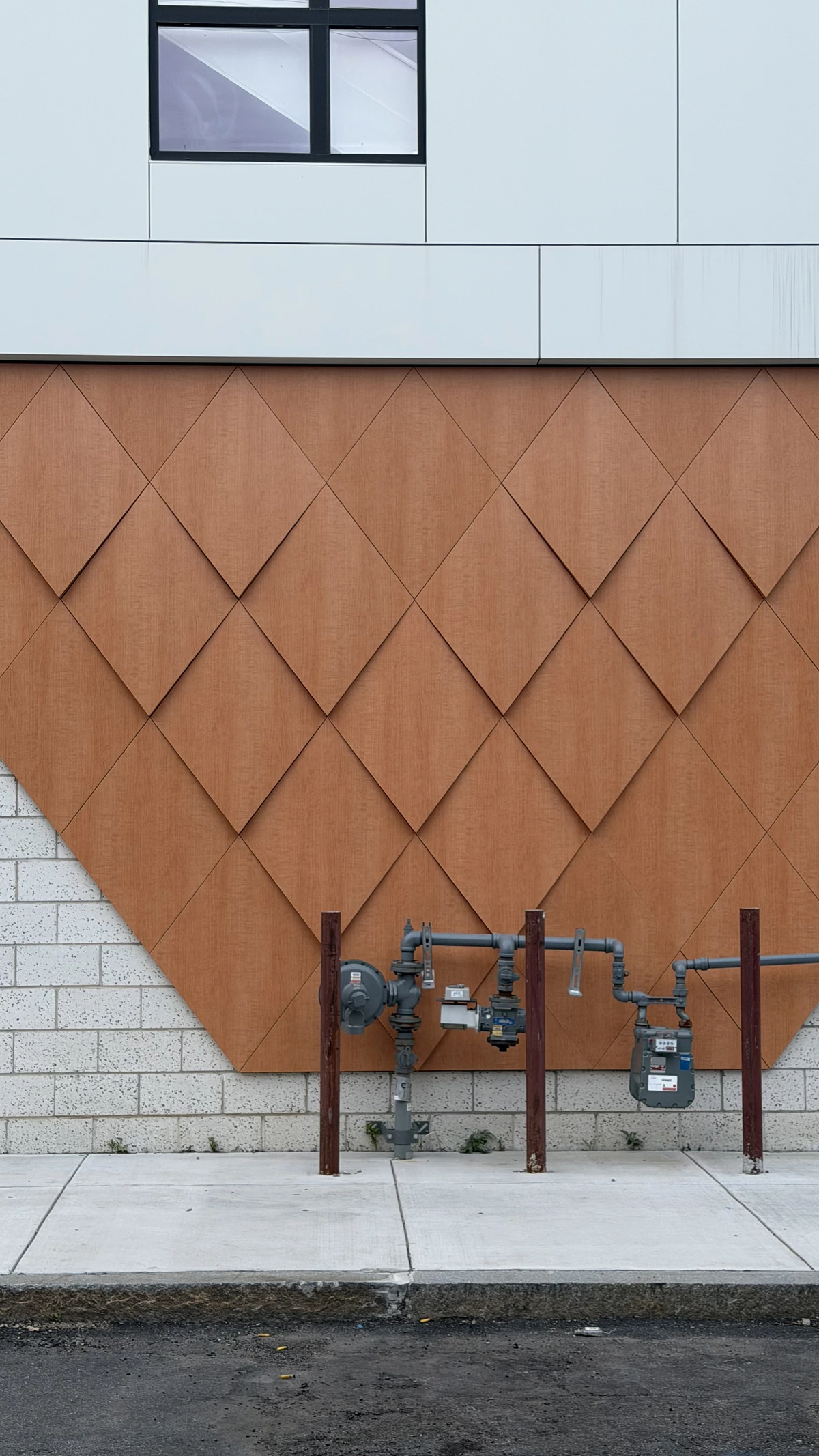 Wood-look ACM diamond relief panels above a masonry base, Boston