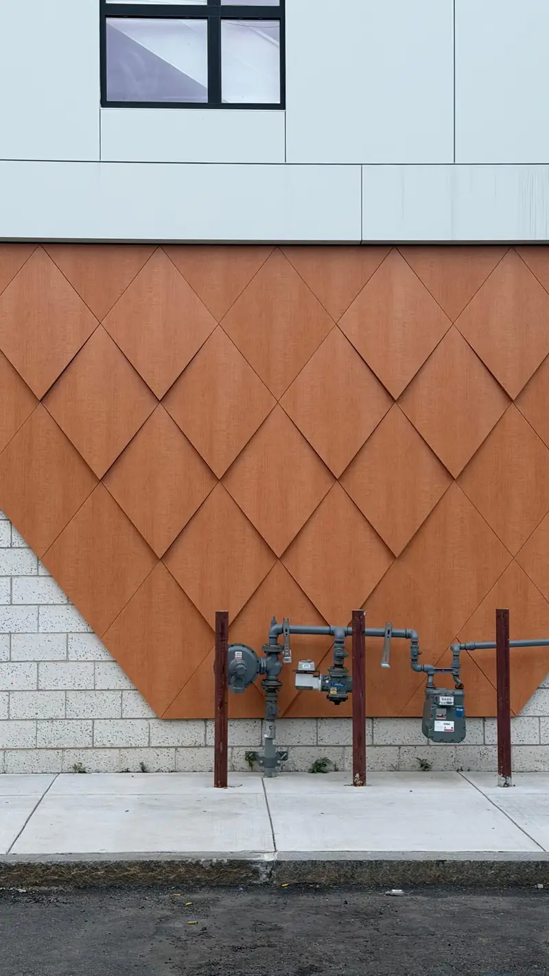 Wood-look ACM diamond relief panels above a masonry base, Boston